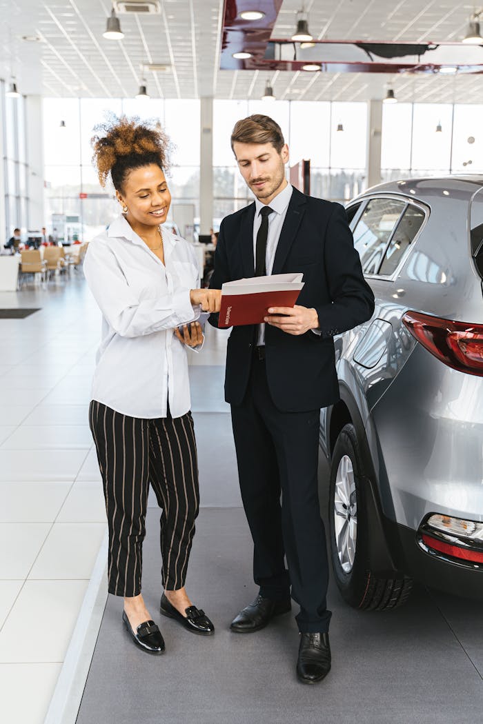 services-04 Man and woman discussing car purchase inside a modern dealership.